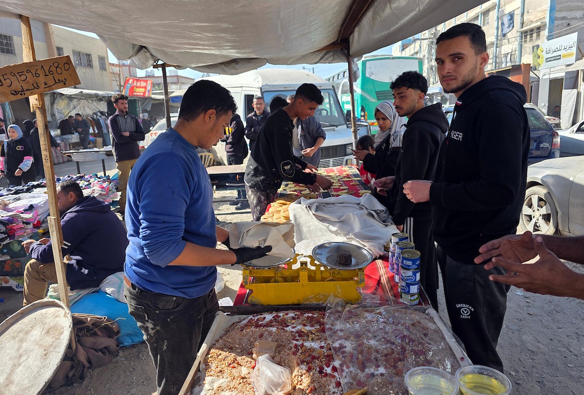 بائعٌ يُعدّ حلوى القطايف الشهيرة بالطرق التقليدية احتفالاً بشهر رمضان المبارك. ورغم الظروف المعيشية الصعبة، يواصل السكان شراء هذه الحلوى التقليدية. خان يونس، جنوب قطاع غزة، ٢٢ فبراير ٢٠٢٦. تصوير: طارق محمد