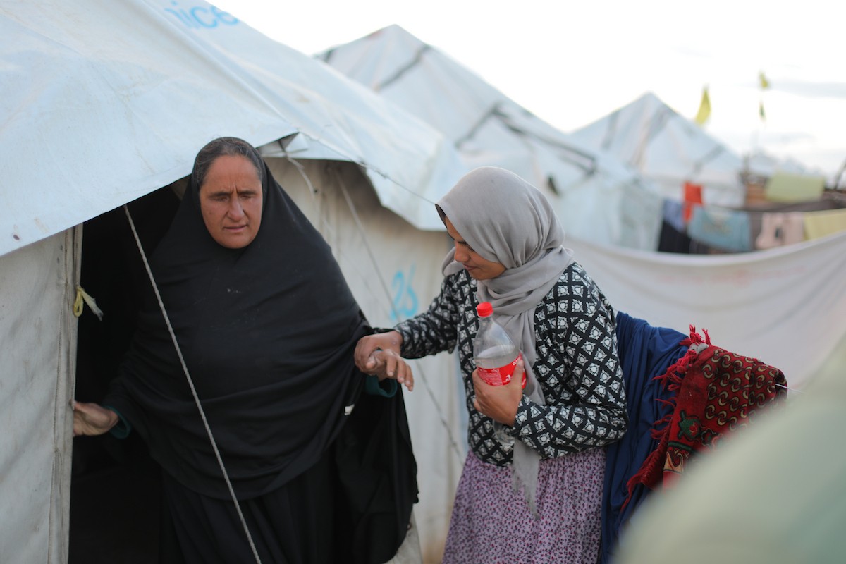 عائلة فلسطينية كفيفة تتناول وجبة الإفطار خارج خيمتها في مخيم بوسط قطاع غزة خلال شهر رمضان