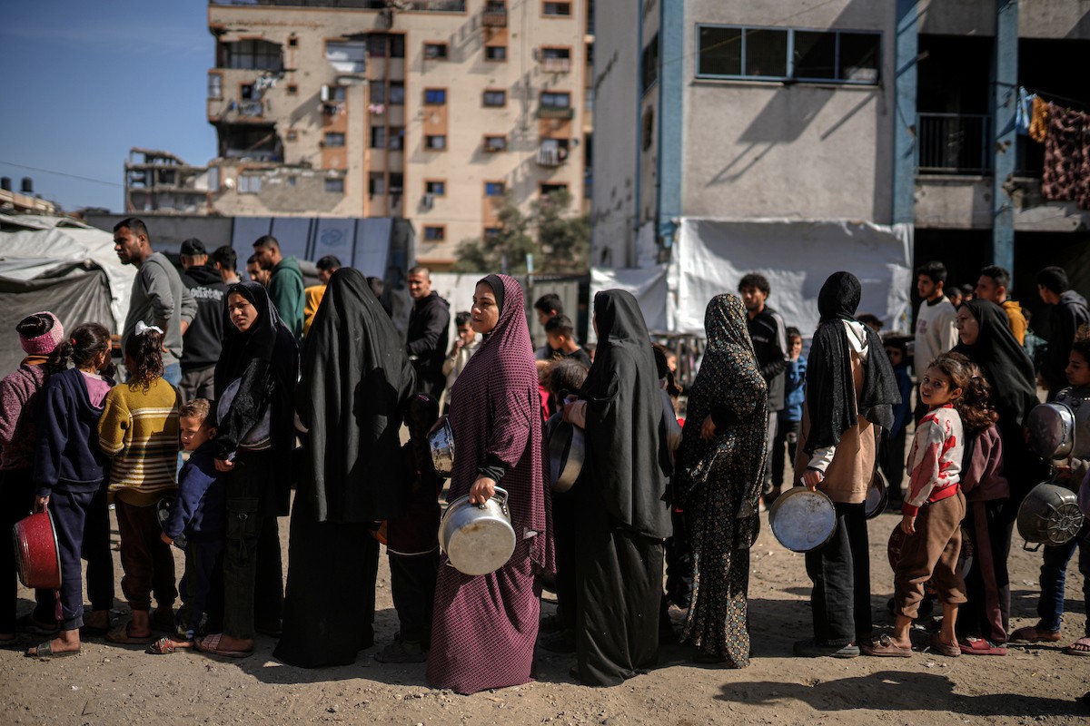 فلسطينيون بينهم أطفال ونساء يتلقون مساعدات غذائية وزعتها منظمات خيرية في أحد مراكز الإيواء بمدينة غزة، وسط أزمة غذائية مستمرة ناجمة عن محدودية المساعدات الإنسانية والظروف الإنسانية المتردية التي يواجهها النازحون، ١٢ فبراير/شباط ٢٠٢٦. تصوير: عمر أشتوي