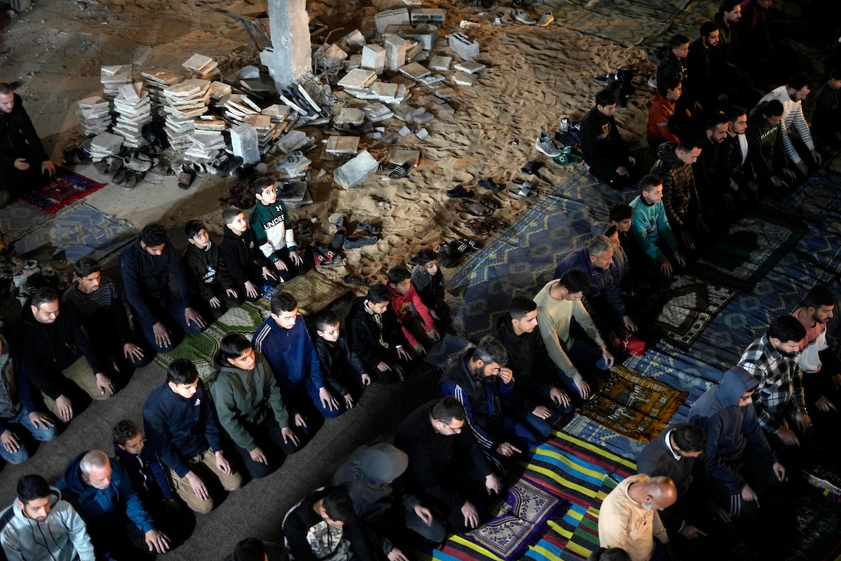 فلسطينيون يؤدون صلاة التراويح في أول ليلة من شهر رمضان على أنقاض مسجد الكنز المدمر في مدينة غزة، في 17 فبراير/شباط 2026. وكان مفتي القدس والأراضي الفلسطينية قد أعلن أن يوم الأربعاء 18 فبراير/شباط 2026 هو أول أيام رمضان. (صورة: عمر أشتوي)