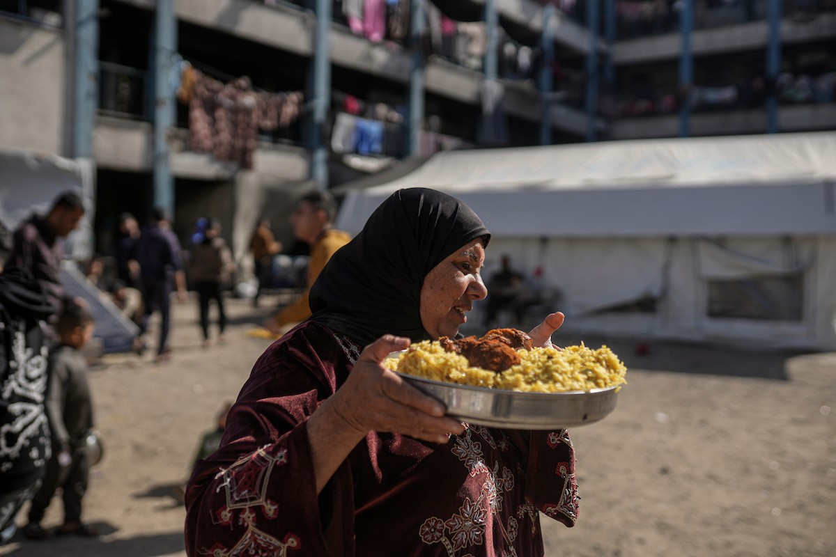 فلسطينيون بينهم أطفال ونساء يتلقون مساعدات غذائية وزعتها منظمات خيرية في أحد مراكز الإيواء بمدينة غزة، وسط أزمة غذائية مستمرة ناجمة عن محدودية المساعدات الإنسانية والظروف الإنسانية المتردية التي يواجهها النازحون، ١٢ فبراير/شباط ٢٠٢٦. تصوير: عمر أشتوي