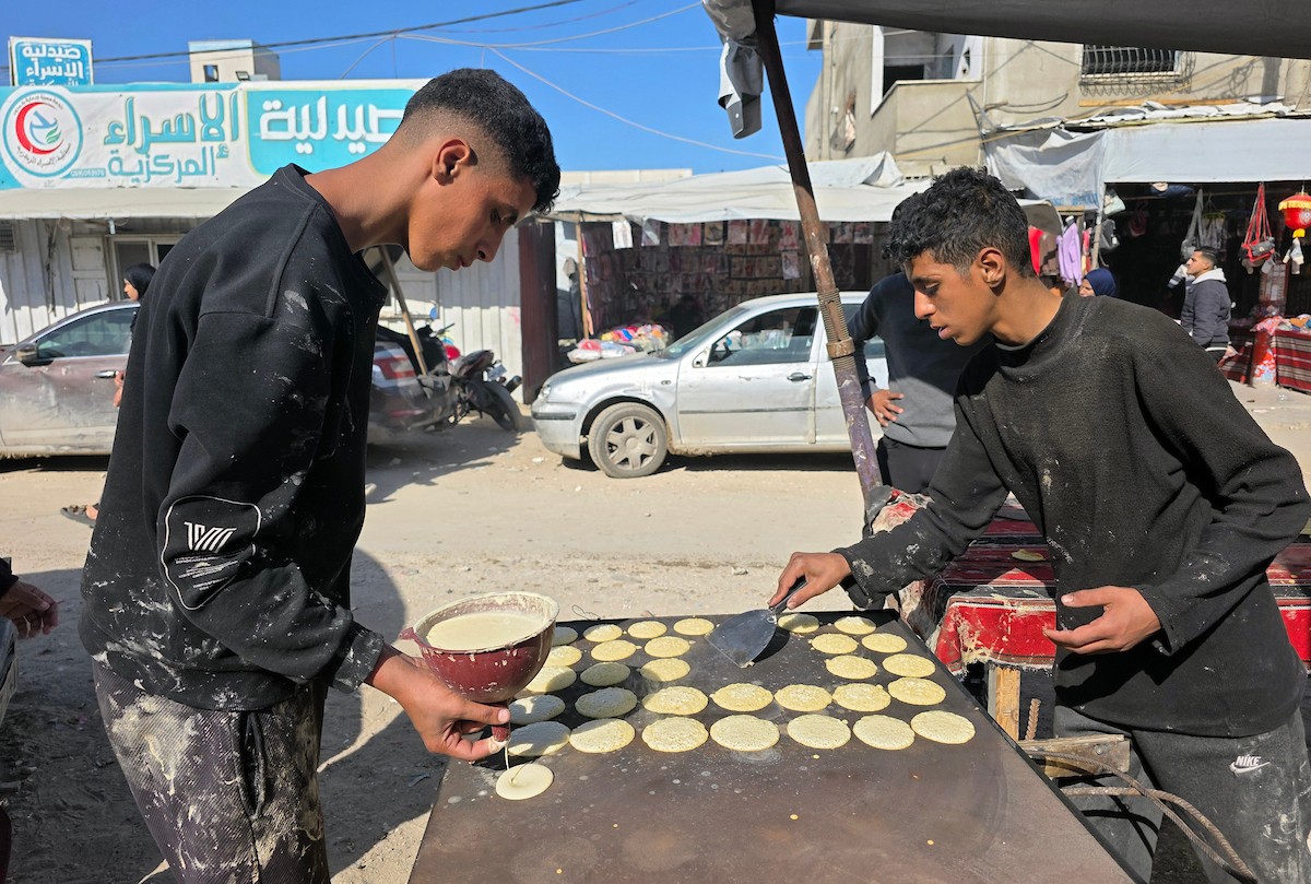 بائعٌ يُعدّ حلوى القطايف الشهيرة بالطرق التقليدية احتفالاً بشهر رمضان المبارك. ورغم الظروف المعيشية الصعبة، يواصل السكان شراء هذه الحلوى التقليدية. خان يونس، جنوب قطاع غزة، ٢٢ فبراير ٢٠٢٦. تصوير: طارق محمد
