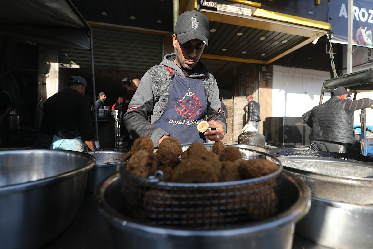 مشهد من الأسواق والبازارات في مخيم النصيرات، وسط قطاع غزة، حيث يستعد المواطنون للإفطار خلال شهر رمضان، في 22 فبراير/شباط 2026. تصوير: معز صالحي