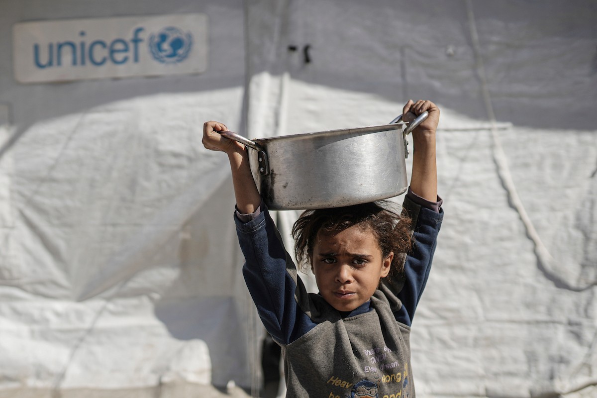 فلسطينيون بينهم أطفال ونساء يتلقون مساعدات غذائية وزعتها منظمات خيرية في أحد مراكز الإيواء بمدينة غزة، وسط أزمة غذائية مستمرة ناجمة عن محدودية المساعدات الإنسانية والظروف الإنسانية المتردية التي يواجهها النازحون، ١٢ فبراير/شباط ٢٠٢٦. تصوير: عمر أشتوي