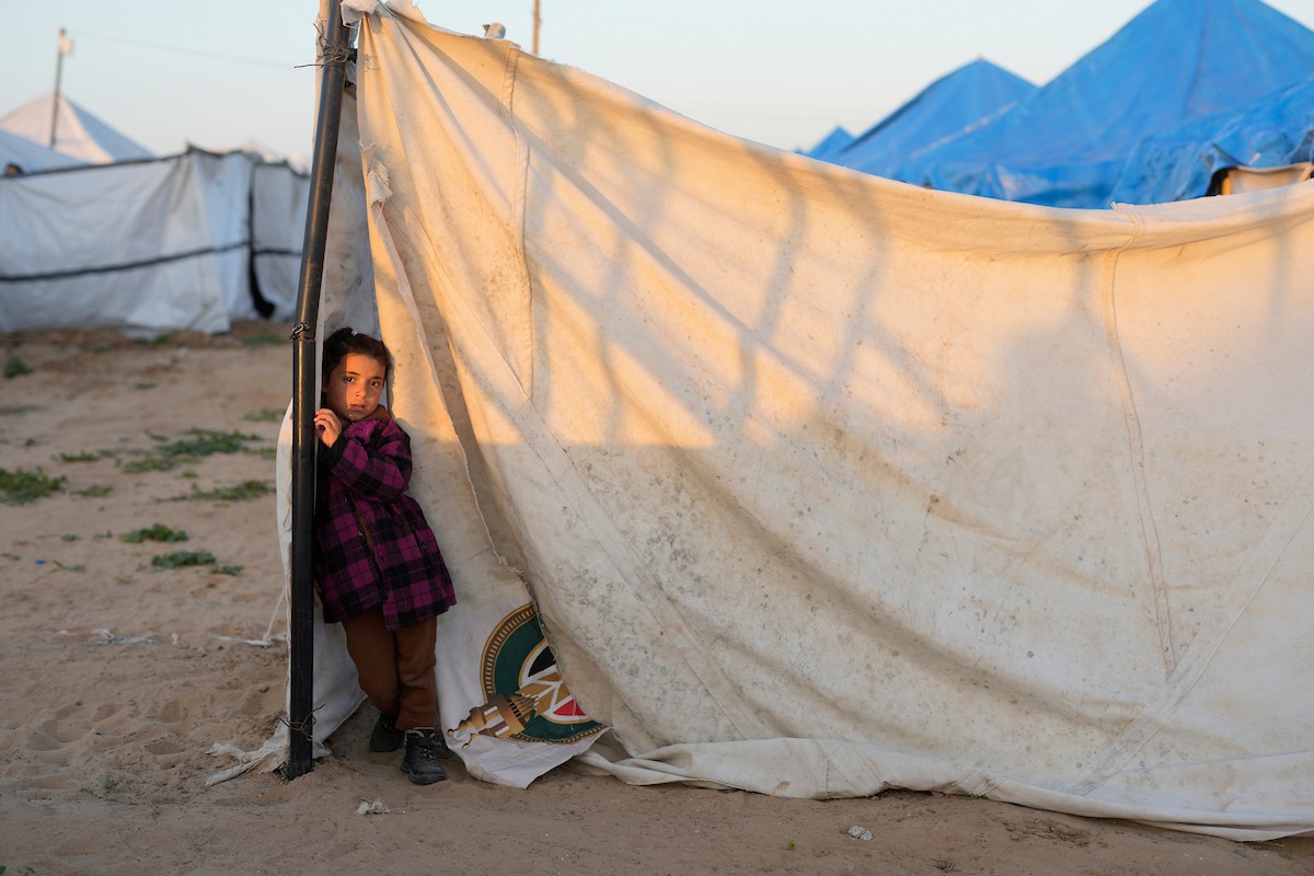 يتجمع فلسطينيون نازحون لتناول وجبة الإفطار، وهي وجبة كسر الصيام، خلال شهر رمضان المبارك في مخيم خيام يؤويهم، بحي الزهراء وسط قطاع غزة، يوم السبت 21 فبراير/شباط 2026. تصوير: عمر أشتوي