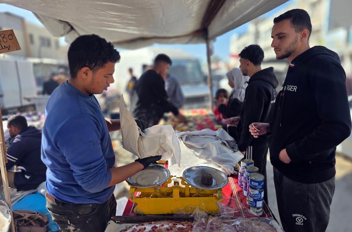 بائعٌ يُعدّ حلوى القطايف الشهيرة بالطرق التقليدية احتفالاً بشهر رمضان المبارك. ورغم الظروف المعيشية الصعبة، يواصل السكان شراء هذه الحلوى التقليدية. خان يونس، جنوب قطاع غزة، ٢٢ فبراير ٢٠٢٦. تصوير: طارق محمد