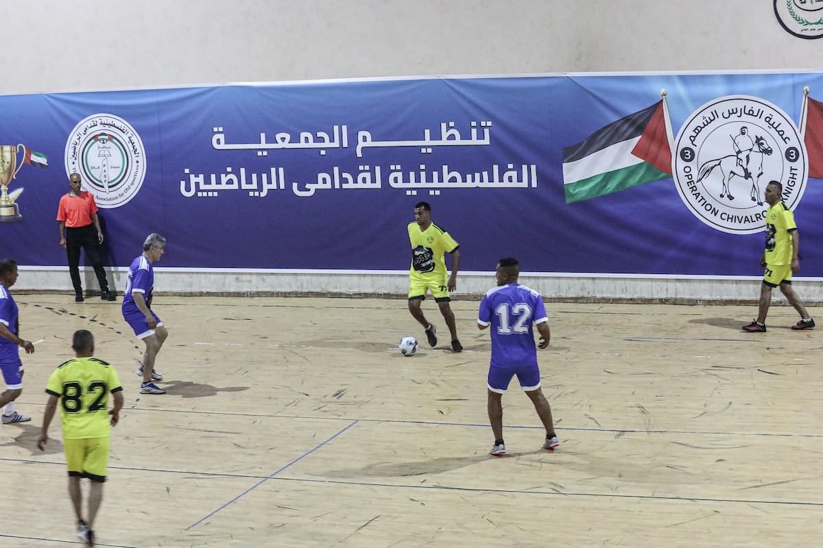 لاعبون فلسطينيون من فريقي النصيرات ورفح يتنافسون خلال مباراة كرة قدم على ملعب نادي خدمات النصيرات، ضمن بطولة غزة الرمضانية، بحضور حشد جماهيري كبير، في مخيم النصيرات بوسط قطاع غزة، بتاريخ 21 فبراير/شباط 2026. تصوير: معز صالحي / apaimages