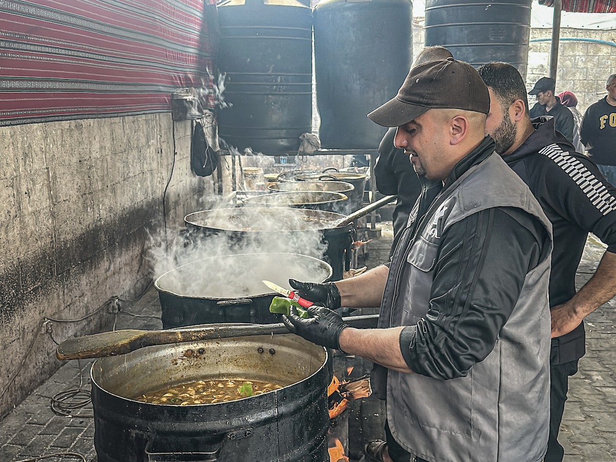 يتجمع فلسطينيون نازحون لتناول وجبة إفطارهم الرمضانية في مطبخ خيري بمخيم النصيرات للاجئين وسط قطاع غزة، في 24 فبراير/شباط 2026. ويواجه النازحون ظروفًا معيشية قاسية نتيجة انعدام الدخل ونقص المساعدات الإنسانية. (صورة: رمزي أبو عامر / apaimages)