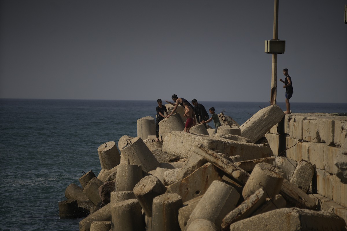 يسبح أطفال قرب ميناء غزة المدمر، في مشهد يعكس تمسكهم بلحظات الفرح رغم الدمار المحيط بهم. يُعدّ البحر في غزة المتنفس الوحيد لسكانها الذين يواجهون آثار الحرب والنزوح، والذين يعيشون في خيام تفتقر لأبسط مقومات الحياة، ١٢ فبراير ٢٠٢٦. تصوير: عمر أشتوي