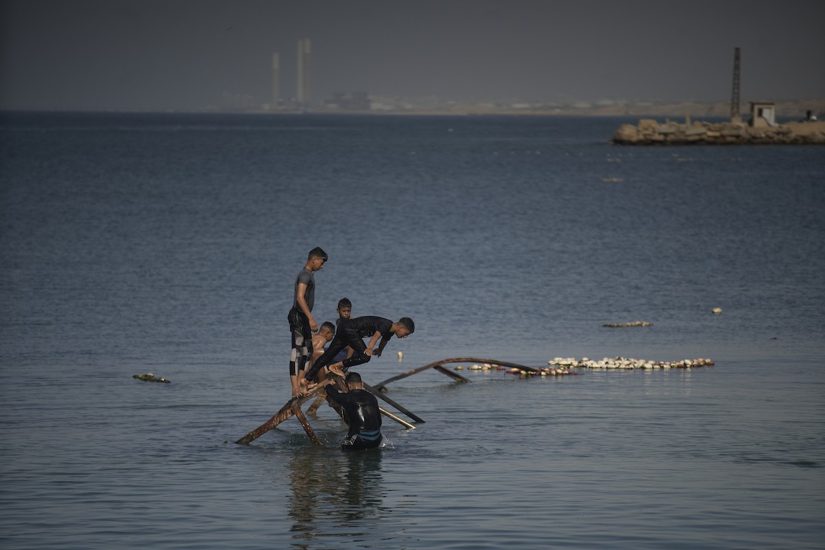 يسبح أطفال قرب ميناء غزة المدمر، في مشهد يعكس تمسكهم بلحظات الفرح رغم الدمار المحيط بهم. يُعدّ البحر في غزة المتنفس الوحيد لسكانها الذين يواجهون آثار الحرب والنزوح، والذين يعيشون في خيام تفتقر لأبسط مقومات الحياة، ١٢ فبراير ٢٠٢٦. تصوير: عمر أشتوي