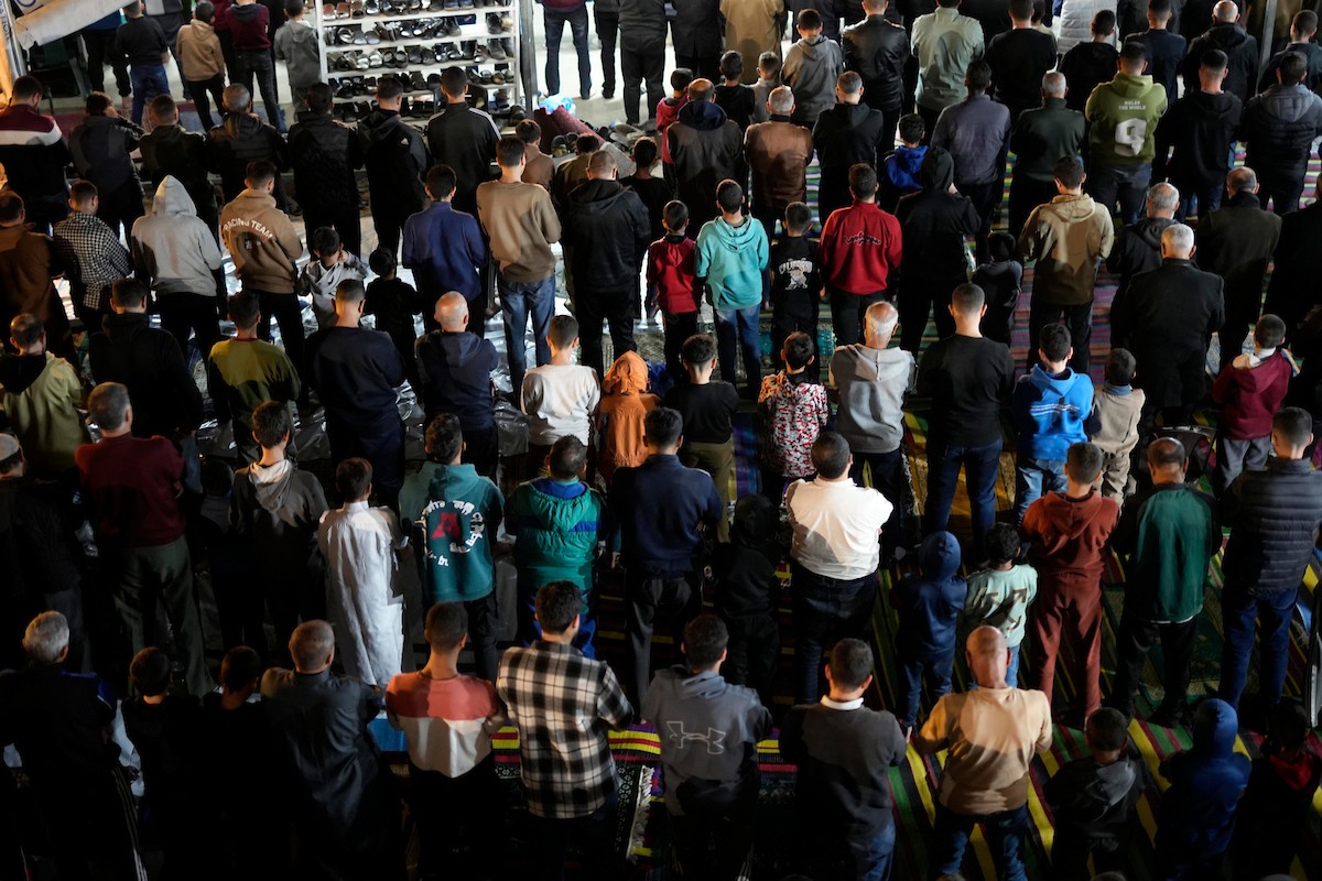 فلسطينيون يؤدون صلاة التراويح في أول ليلة من شهر رمضان على أنقاض مسجد الكنز المدمر في مدينة غزة، في 17 فبراير/شباط 2026. وكان مفتي القدس والأراضي الفلسطينية قد أعلن أن يوم الأربعاء 18 فبراير/شباط 2026 هو أول أيام رمضان. (صورة: عمر أشتوي)