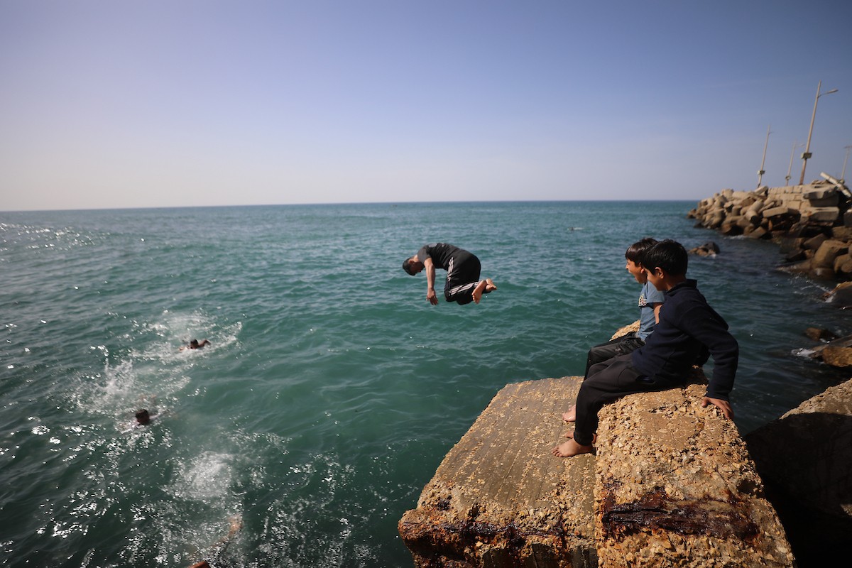 يسبح أطفال قرب ميناء غزة المدمر، في مشهد يعكس تمسكهم بلحظات الفرح رغم الدمار المحيط بهم. يُعدّ البحر في غزة المتنفس الوحيد لسكانها الذين يواجهون آثار الحرب والنزوح، والذين يعيشون في خيام تفتقر لأبسط مقومات الحياة، ١٢ فبراير ٢٠٢٦. تصوير: عمر أشتوي
