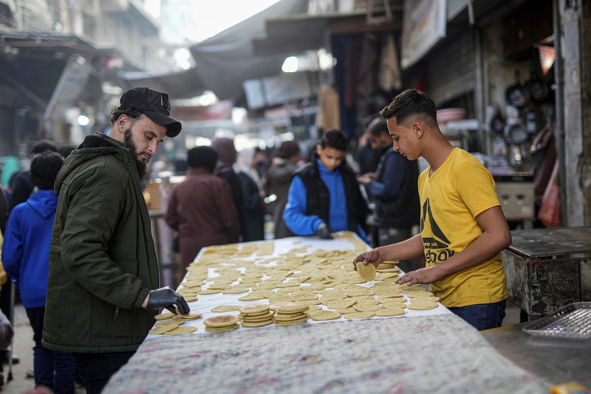 يتسوق الفلسطينيون في أول ليلة من شهر رمضان المبارك في سوق الزاوية، الواقع في قلب مدينة غزة والذي تضرر بشدة جراء الحرب الإسرائيلية. يعرض الباعة بضائعهم على أكشاك مزينة بالفوانيس والأضواء وأطعمة رمضان. مدينة غزة، 17 فبراير/شباط 2026. تصوير: عمر أشتوي