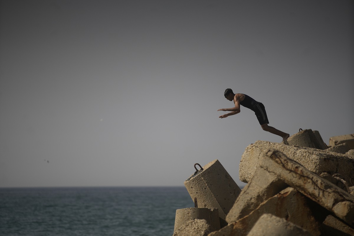 يسبح أطفال قرب ميناء غزة المدمر، في مشهد يعكس تمسكهم بلحظات الفرح رغم الدمار المحيط بهم. يُعدّ البحر في غزة المتنفس الوحيد لسكانها الذين يواجهون آثار الحرب والنزوح، والذين يعيشون في خيام تفتقر لأبسط مقومات الحياة، ١٢ فبراير ٢٠٢٦. تصوير: عمر أشتوي