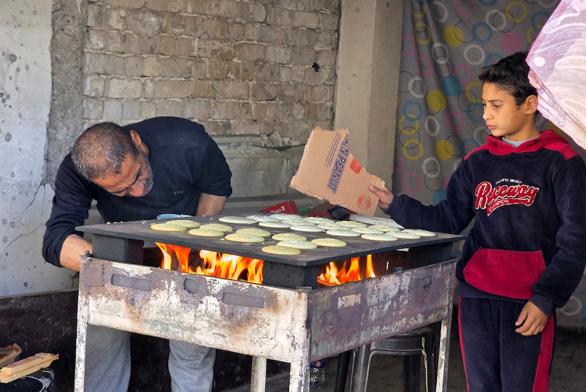 سليم البيوك ُيعدّ معجنات القطايف التقليدية باستخدام أساليب بدائية تعتمد على الحطب والنارمُواصلاً إحياء تقاليد شهر رمضان منذ أكثر من 20 عاماً، في سوق كراج رفح في خان يونس، جنوب قطاع غزة، في 12 فبراير/شباط 2026.تصوير: طارق محمد