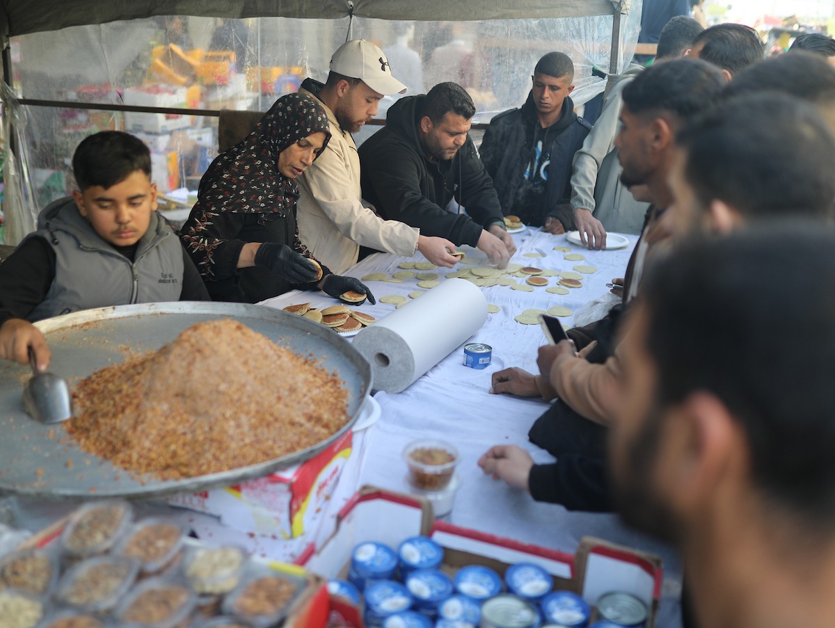 آلاء كريم نازحة في مخيم النصيرات وسط قطاع غزة، تفتح كشكًا لتحضير وبيع القطايف خلال أيام رمضان، في محاولة منها للتغلب على ظروف المعيشة القاسية وإعالة أسرتها بعد أن فقدت منزلها، 19 فبرايرشباط 2026. تصوير رمزي أبو عامر