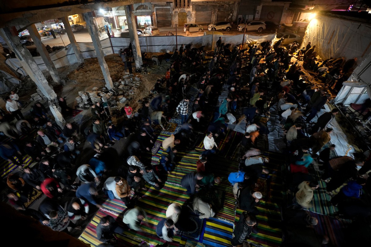 فلسطينيون يؤدون صلاة التراويح في أول ليلة من شهر رمضان على أنقاض مسجد الكنز المدمر في مدينة غزة، في 17 فبراير/شباط 2026. وكان مفتي القدس والأراضي الفلسطينية قد أعلن أن يوم الأربعاء 18 فبراير/شباط 2026 هو أول أيام رمضان. (صورة: عمر أشتوي)