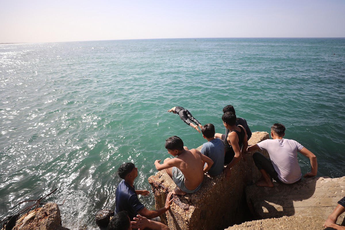 يسبح أطفال قرب ميناء غزة المدمر، في مشهد يعكس تمسكهم بلحظات الفرح رغم الدمار المحيط بهم. يُعدّ البحر في غزة المتنفس الوحيد لسكانها الذين يواجهون آثار الحرب والنزوح، والذين يعيشون في خيام تفتقر لأبسط مقومات الحياة، ١٢ فبراير ٢٠٢٦. تصوير: عمر أشتوي