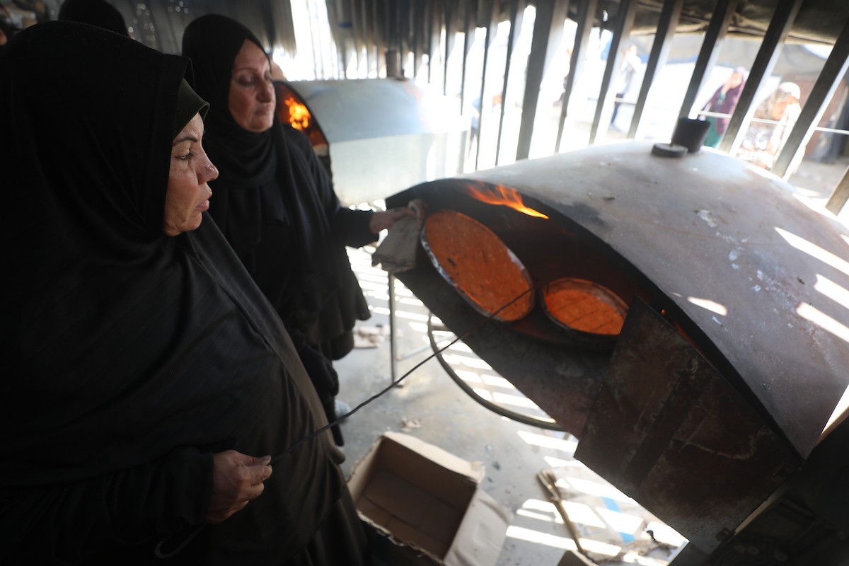 مجموعة من النساء يعملن داخل مخبز أُنشئ في مخيم اليرموك للاجئين بمدينة غزة، ضمن مبادرة إنسانية بالشراكة مع اللجنة الدولية للصليب الأحمر. تهدف المبادرة إلى تخفيف الأعباء المعيشية عن النساء النازحات، لا سيما خلال شهر رمضان. مدينة غزة، 25 فبراير/شباط 2026. تصوير: عمر أشتوي