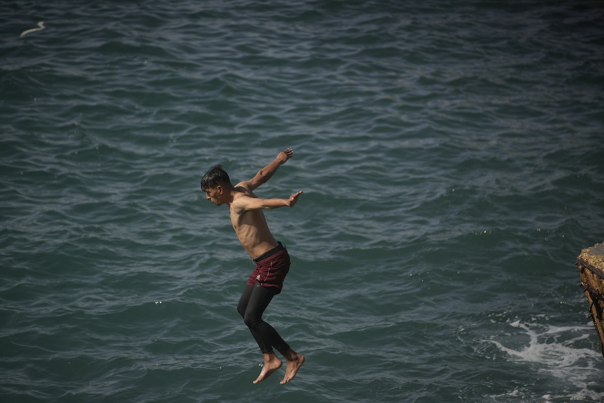 يسبح أطفال قرب ميناء غزة المدمر، في مشهد يعكس تمسكهم بلحظات الفرح رغم الدمار المحيط بهم. يُعدّ البحر في غزة المتنفس الوحيد لسكانها الذين يواجهون آثار الحرب والنزوح، والذين يعيشون في خيام تفتقر لأبسط مقومات الحياة، ١٢ فبراير ٢٠٢٦. تصوير: عمر أشتوي