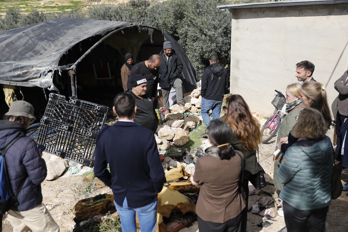 وفد دبلوماسي أوروبي يزور قرية سوسيا، جنوب الخليل، لتقييم الأضرار التي لحقت بالممتلكات الفلسطينية جراء هجمات المستوطنين، 25 فبراير/شباط 2026. تصوير: مأمون وزواز