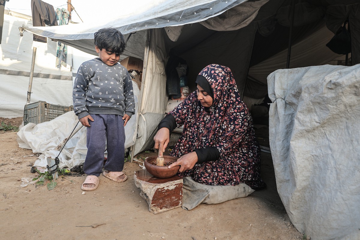عائلة فلسطينية نازحة تتناول فطورها خلال شهر رمضان داخل خيمة متداعية في مخيم النصيرات للاجئين وسط قطاع غزة. تواجه العائلات النازحة ظروفًا معيشية قاسية نتيجة الحرب، مع انعدام الدخل ونقص حاد في المساعدات الإنسانية، 26 فبراير/شباط 2026. تصوير: معز صالحي