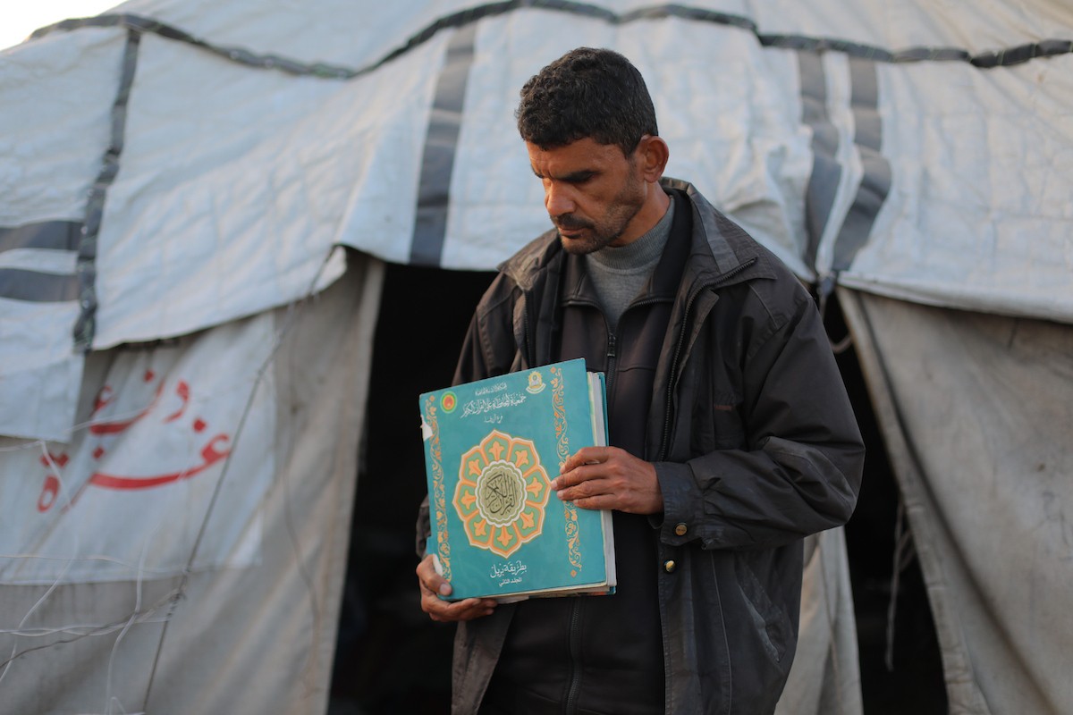 عائلة فلسطينية كفيفة تتناول وجبة الإفطار خارج خيمتها في مخيم بوسط قطاع غزة خلال شهر رمضان