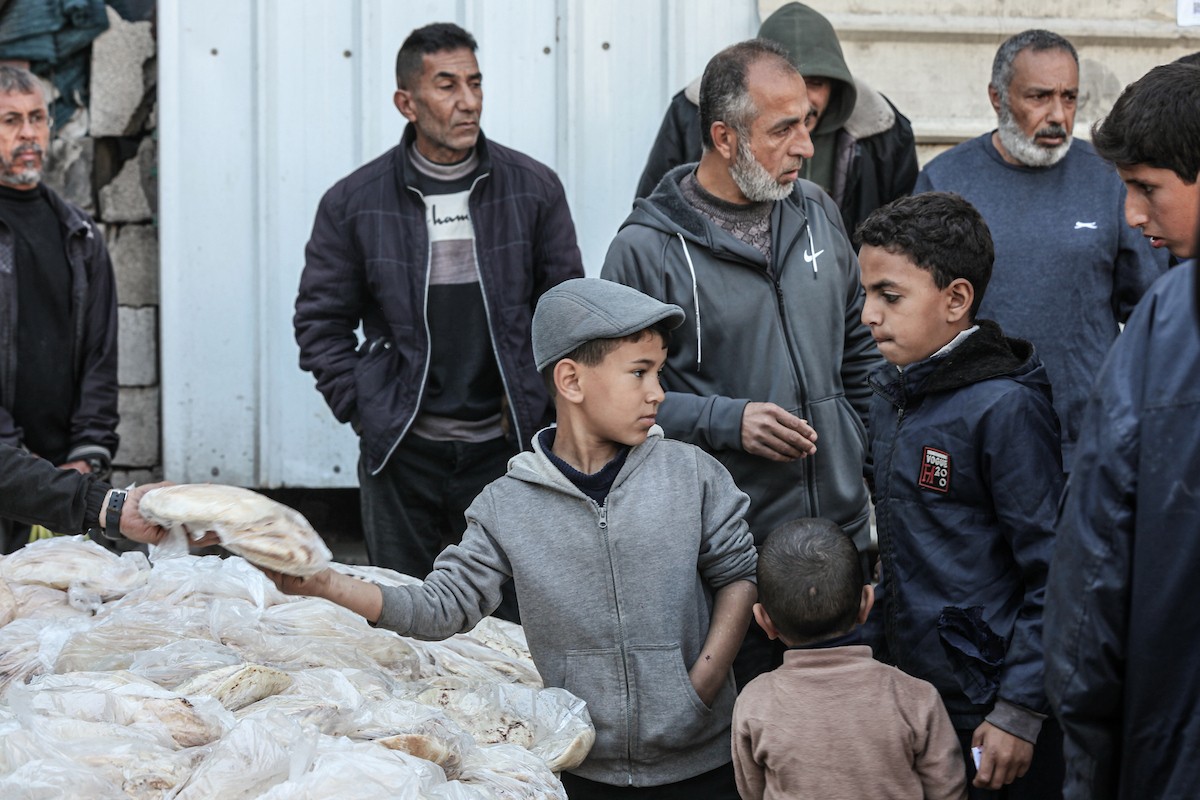 نساء فلسطينيات، زوجات شهداء الحرب، يُجهّزن الخبز لتوزيعه على العائلات النازحة والمحتاجة في مخيم البريج للاجئين وسط قطاع غزة خلال شهر رمضان، في مشهد يُجسّد روح التضامن والصمود في ظلّ الظروف الإنسانية الصعبة، فبراير/شباط 2026. تصوير: معز صالحي