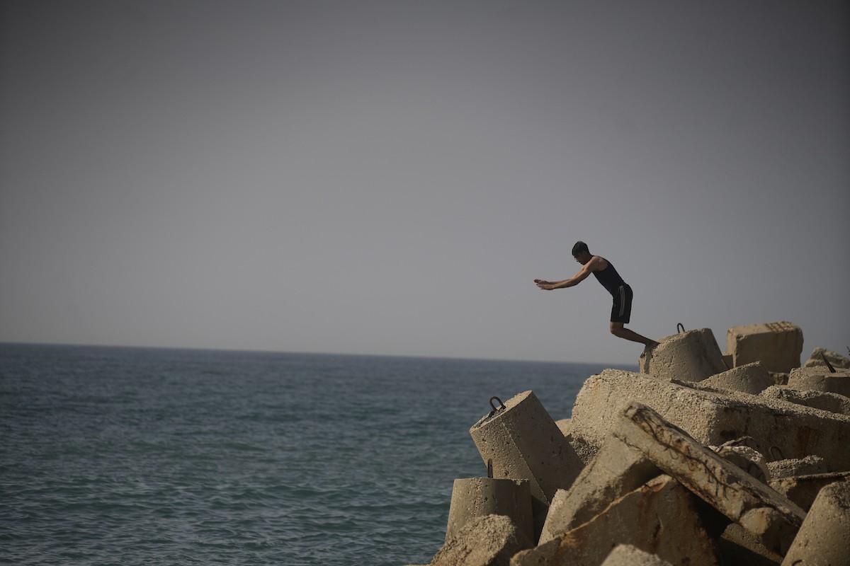 يسبح أطفال قرب ميناء غزة المدمر، في مشهد يعكس تمسكهم بلحظات الفرح رغم الدمار المحيط بهم. يُعدّ البحر في غزة المتنفس الوحيد لسكانها الذين يواجهون آثار الحرب والنزوح، والذين يعيشون في خيام تفتقر لأبسط مقومات الحياة، ١٢ فبراير ٢٠٢٦. تصوير: عمر أشتوي