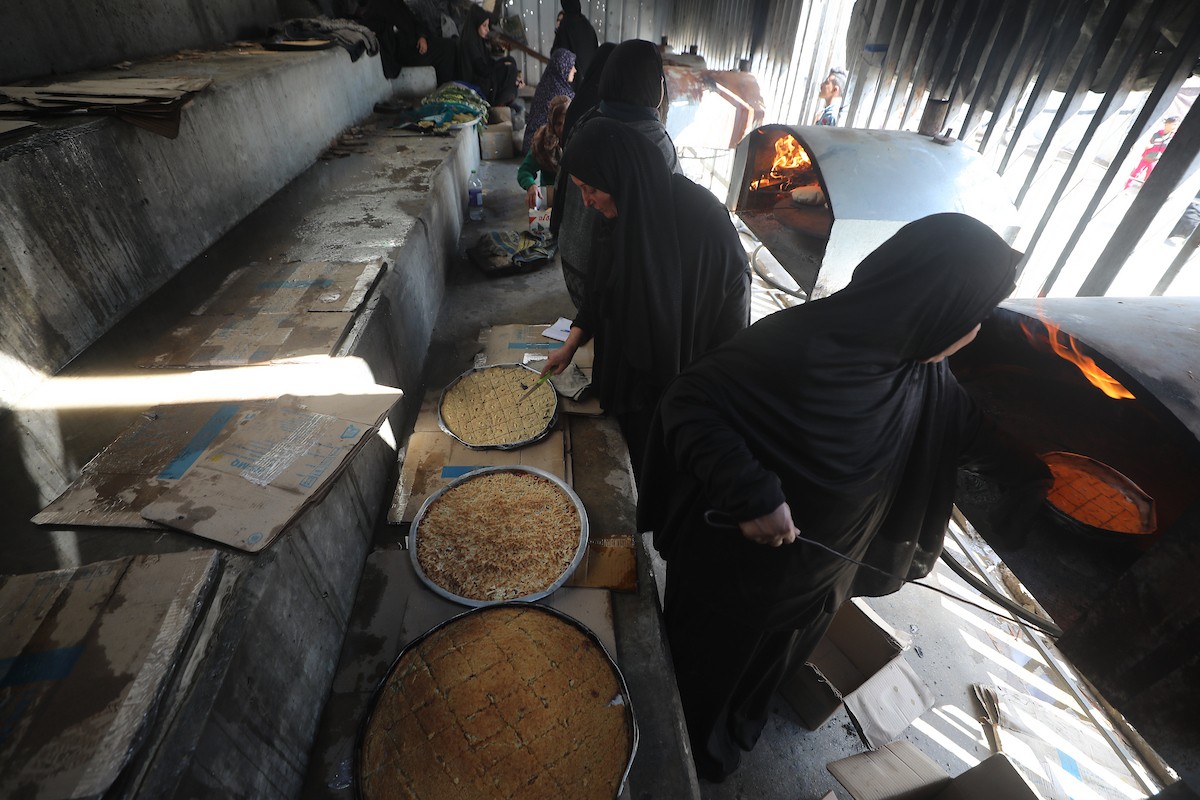 مجموعة من النساء يعملن داخل مخبز أُنشئ في مخيم اليرموك للاجئين بمدينة غزة، ضمن مبادرة إنسانية بالشراكة مع اللجنة الدولية للصليب الأحمر. تهدف المبادرة إلى تخفيف الأعباء المعيشية عن النساء النازحات، لا سيما خلال شهر رمضان. مدينة غزة، 25 فبراير/شباط 2026. تصوير: عمر أشتوي
