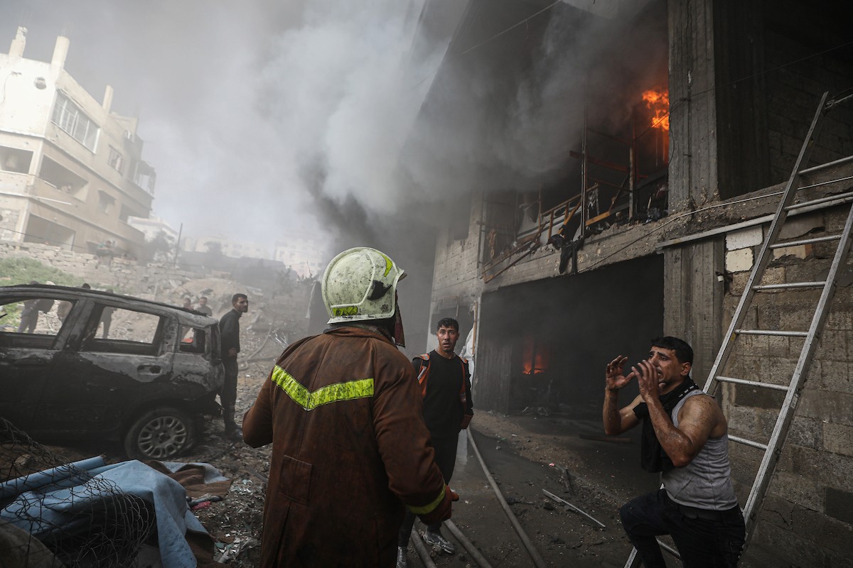 طواقم الدفاع المدني ومتطوعون من المواطنين أثناء محاولة إخماد حريق اندلع في مستودع تابع لمنظمة إغاثة في حي الرمال، غرب مدينة غزة، في 13 فبراير/شباط 2026. صورة: عمر أشتوي