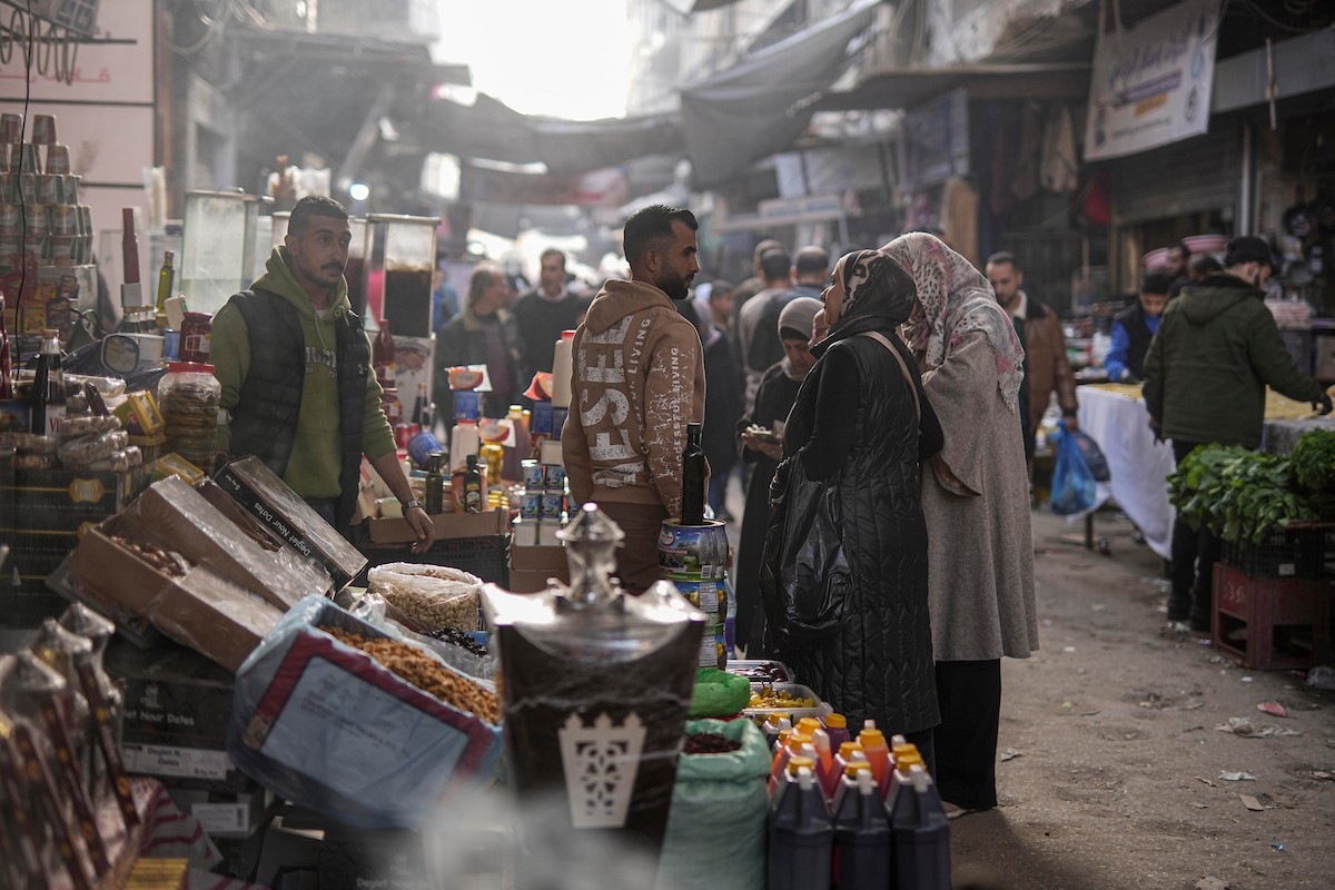 يتسوق الفلسطينيون في أول ليلة من شهر رمضان المبارك في سوق الزاوية، الواقع في قلب مدينة غزة والذي تضرر بشدة جراء الحرب الإسرائيلية. يعرض الباعة بضائعهم على أكشاك مزينة بالفوانيس والأضواء وأطعمة رمضان. مدينة غزة، 17 فبراير/شباط 2026. تصوير: عمر أشتوي