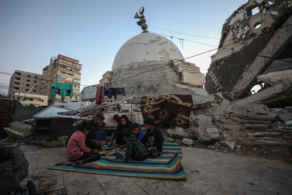 عائلة فلسطينية نازحة من بيت حانون تفطر في ثاني أيام رمضان في خيمة متداعية وسط أنقاض مسجد الحساينة على شاطئ مدينة غزة.19 فبراير/شباط 2026. تصوير: عمر أشتوي