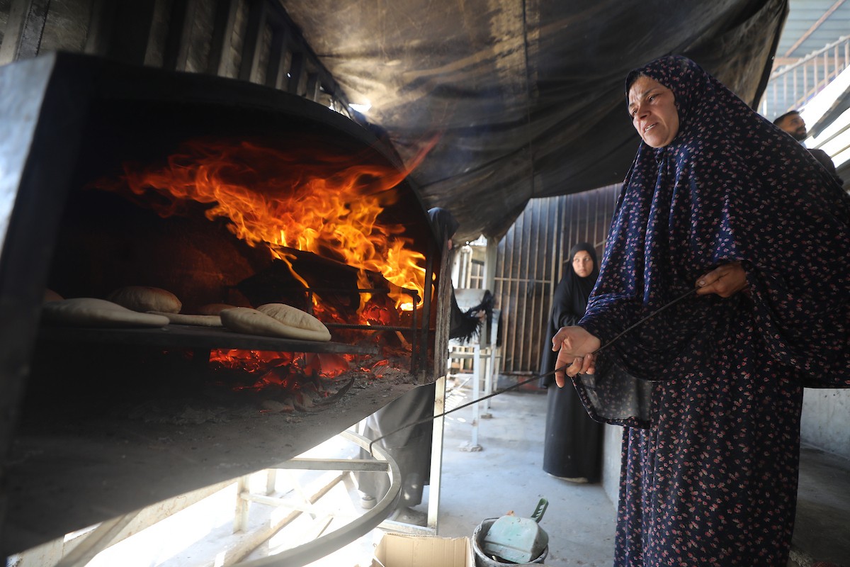 مجموعة من النساء يعملن داخل مخبز أُنشئ في مخيم اليرموك للاجئين بمدينة غزة، ضمن مبادرة إنسانية بالشراكة مع اللجنة الدولية للصليب الأحمر. تهدف المبادرة إلى تخفيف الأعباء المعيشية عن النساء النازحات، لا سيما خلال شهر رمضان. مدينة غزة، 25 فبراير/شباط 2026. تصوير: عمر أشتوي