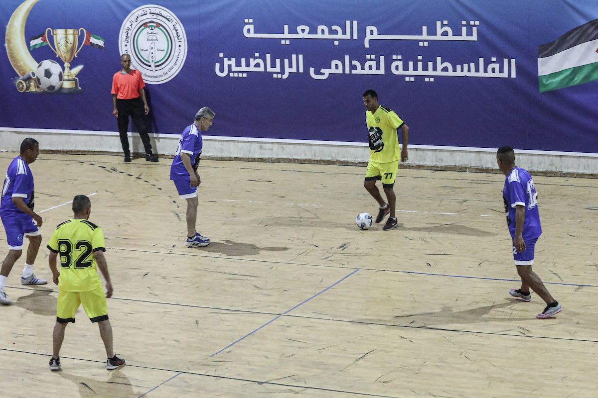 لاعبون فلسطينيون من فريقي النصيرات ورفح يتنافسون خلال مباراة كرة قدم على ملعب نادي خدمات النصيرات، ضمن بطولة غزة الرمضانية، بحضور حشد جماهيري كبير، في مخيم النصيرات بوسط قطاع غزة، بتاريخ 21 فبراير/شباط 2026. تصوير: معز صالحي / apaimages