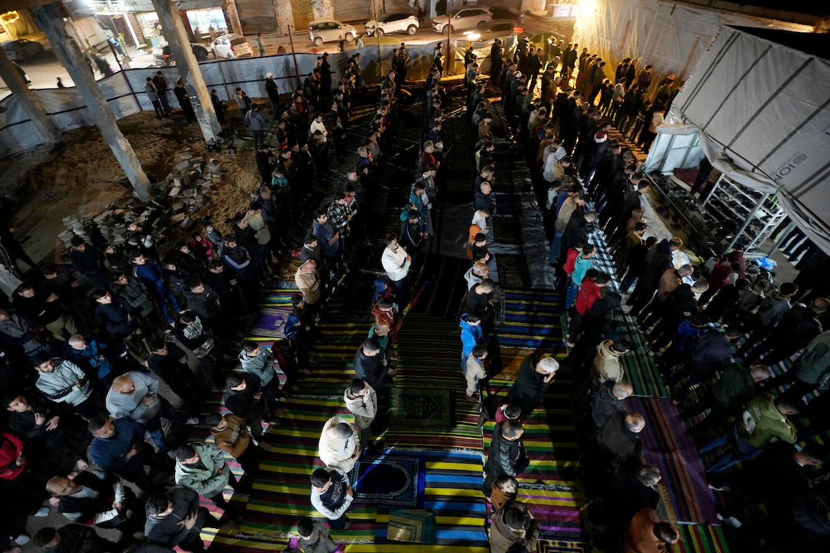 فلسطينيون يؤدون صلاة التراويح في أول ليلة من شهر رمضان على أنقاض مسجد الكنز المدمر في مدينة غزة، في 17 فبراير/شباط 2026. وكان مفتي القدس والأراضي الفلسطينية قد أعلن أن يوم الأربعاء 18 فبراير/شباط 2026 هو أول أيام رمضان. (صورة: عمر أشتوي)