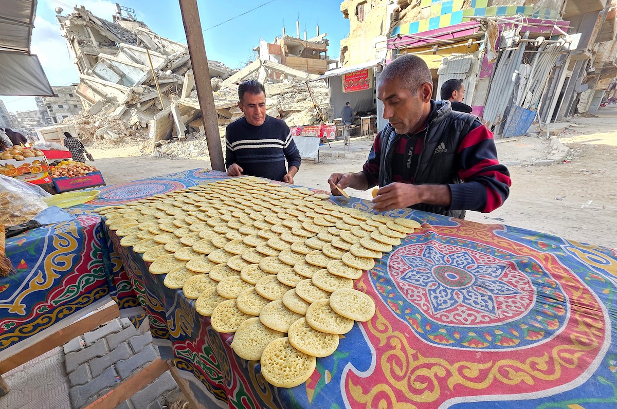 سليم البيوك ُيعدّ معجنات القطايف التقليدية باستخدام أساليب بدائية تعتمد على الحطب والنارمُواصلاً إحياء تقاليد شهر رمضان منذ أكثر من 20 عاماً، في سوق كراج رفح في خان يونس، جنوب قطاع غزة، في 12 فبراير/شباط 2026.تصوير: طارق محمد