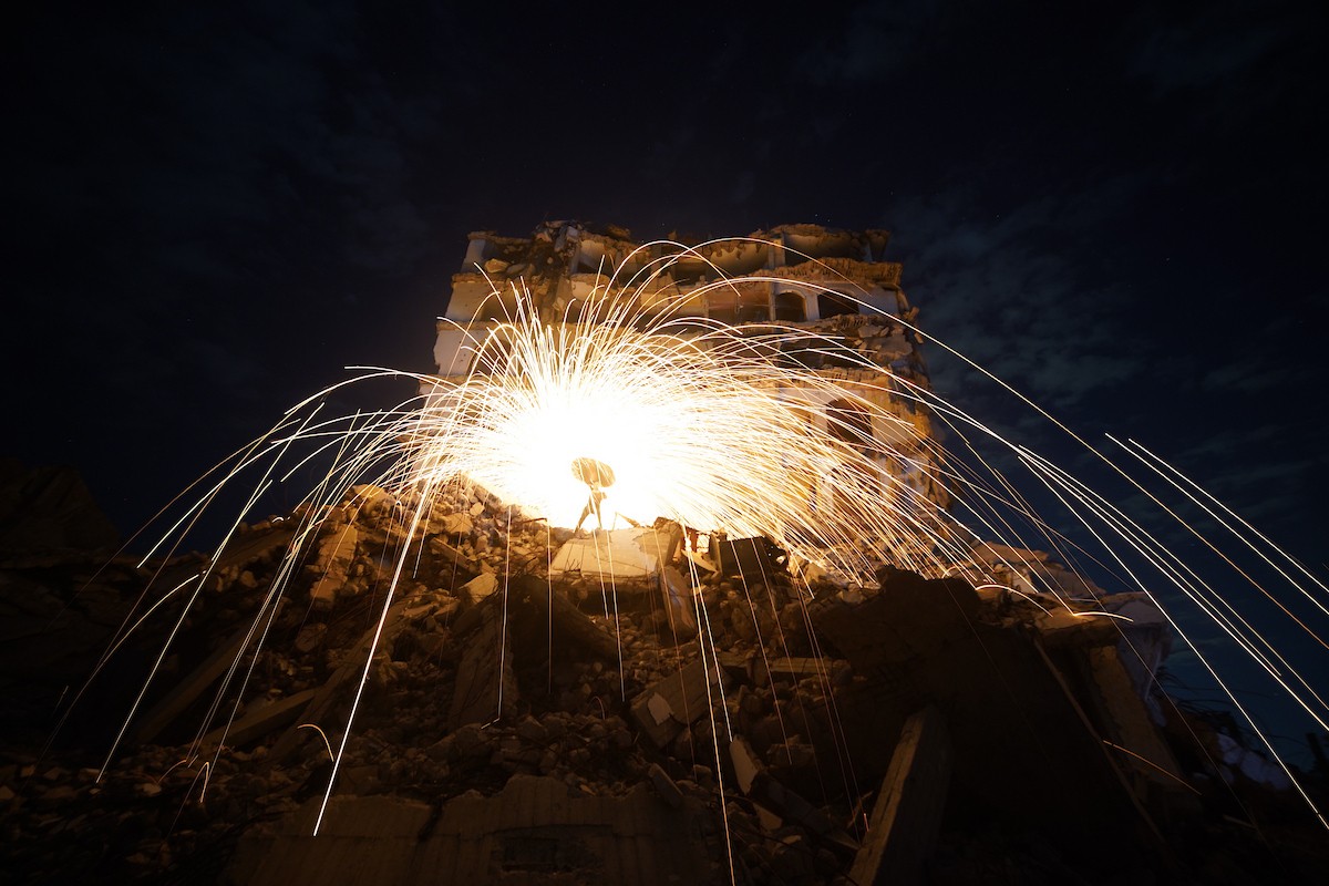 فلسطينيون يُشعلون شرارات من الصوف الفولاذي ( الليف السلكي) خلال شهر رمضان المبارك، وسط أنقاض المباني السكنية التي دُمّرت خلال العدوان الإسرائيلي الذي استمر عامين، في مدينة غزة، 23 فبرايرشباط 2026. صورة عمر أشتوي