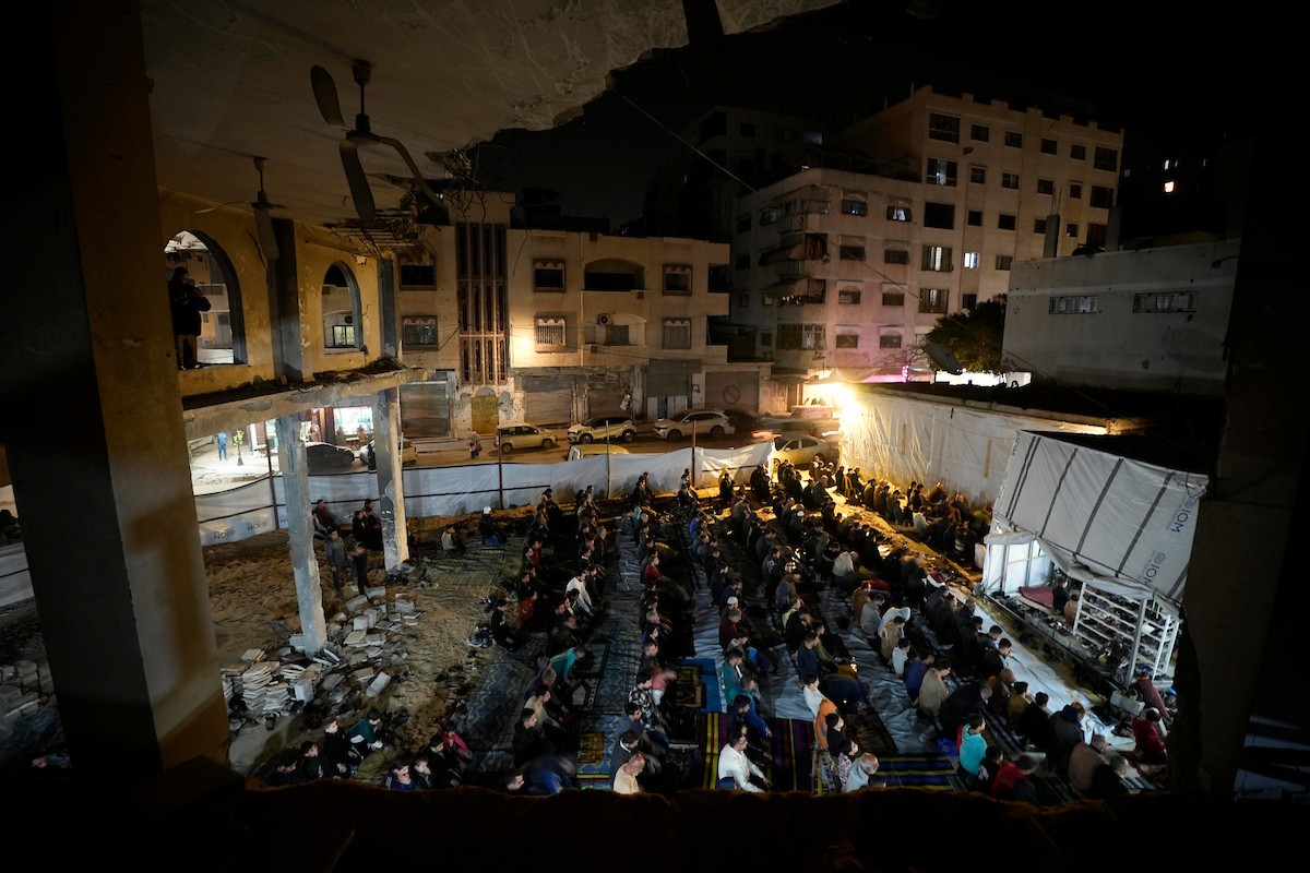 فلسطينيون يؤدون صلاة التراويح في أول ليلة من شهر رمضان على أنقاض مسجد الكنز المدمر في مدينة غزة، في 17 فبراير/شباط 2026. وكان مفتي القدس والأراضي الفلسطينية قد أعلن أن يوم الأربعاء 18 فبراير/شباط 2026 هو أول أيام رمضان. (صورة: عمر أشتوي)