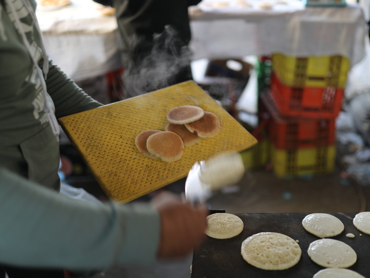 آلاء كريم نازحة في مخيم النصيرات وسط قطاع غزة، تفتح كشكًا لتحضير وبيع القطايف خلال أيام رمضان، في محاولة منها للتغلب على ظروف المعيشة القاسية وإعالة أسرتها بعد أن فقدت منزلها، 19 فبرايرشباط 2026. تصوير رمزي أبو عامر