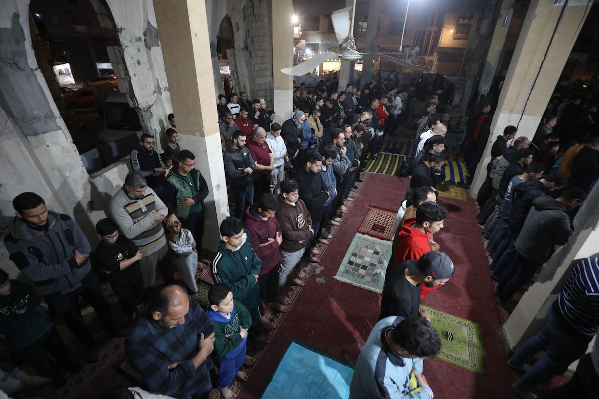 فلسطينيون يؤدون صلاة التراويح في أول ليلة من شهر رمضان على أنقاض مسجد الكنز المدمر في مدينة غزة، في 17 فبراير/شباط 2026. وكان مفتي القدس والأراضي الفلسطينية قد أعلن أن يوم الأربعاء 18 فبراير/شباط 2026 هو أول أيام رمضان. (صورة: عمر أشتوي)