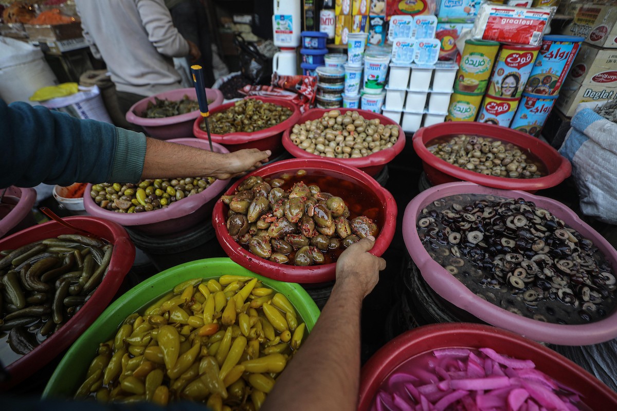 يتسوق الفلسطينيون في أول ليلة من شهر رمضان المبارك في سوق الزاوية، الواقع في قلب مدينة غزة والذي تضرر بشدة جراء الحرب الإسرائيلية. يعرض الباعة بضائعهم على أكشاك مزينة بالفوانيس والأضواء وأطعمة رمضان. مدينة غزة، 17 فبراير/شباط 2026. تصوير: عمر أشتوي