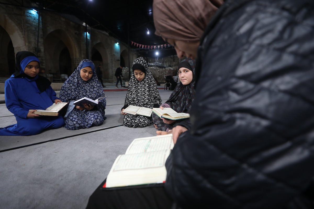 أطفال فلسطينيون يتلون ويحفظون القرآن الكريم داخل الجامع العمري الكبير في مدينة غزة خلال شهر رمضان. وقد تضرر الجامع العمري القديم بشدة جراء الهجمات الإسرائيلية خلال حرب غزة في 26 فبراير/شباط 2026. صورة: عمر أشتوي