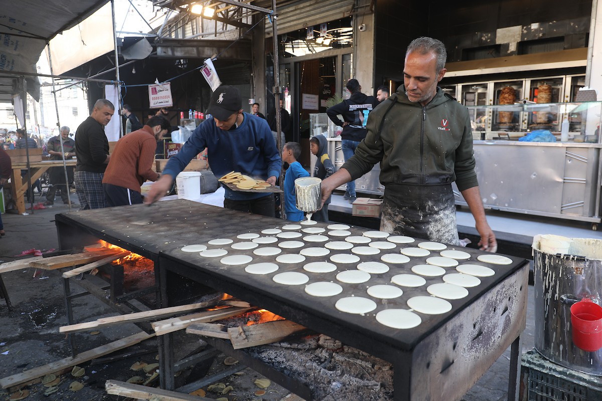 مشهد من الأسواق والبازارات في مخيم النصيرات، وسط قطاع غزة، حيث يستعد المواطنون للإفطار خلال شهر رمضان، في 22 فبراير/شباط 2026. تصوير: معز صالحي