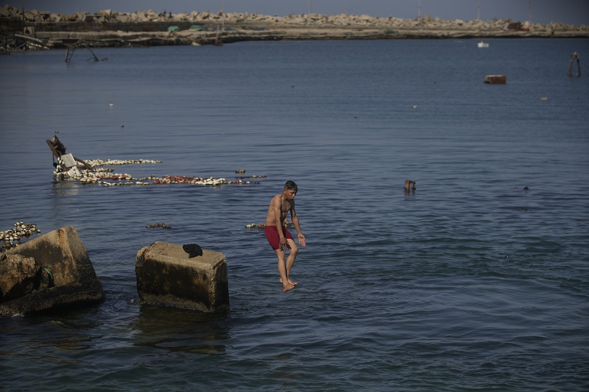 يسبح أطفال قرب ميناء غزة المدمر، في مشهد يعكس تمسكهم بلحظات الفرح رغم الدمار المحيط بهم. يُعدّ البحر في غزة المتنفس الوحيد لسكانها الذين يواجهون آثار الحرب والنزوح، والذين يعيشون في خيام تفتقر لأبسط مقومات الحياة، ١٢ فبراير ٢٠٢٦. تصوير: عمر أشتوي