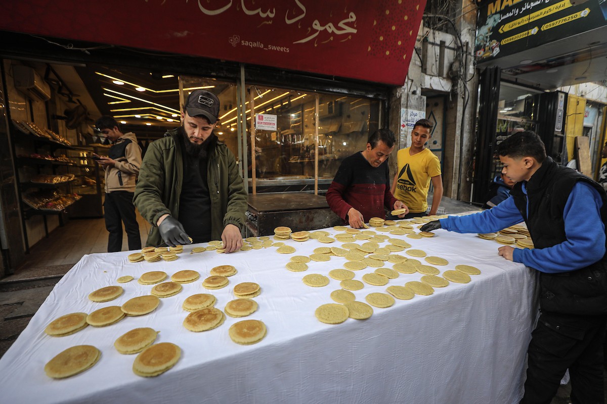 يتسوق الفلسطينيون في أول ليلة من شهر رمضان المبارك في سوق الزاوية، الواقع في قلب مدينة غزة والذي تضرر بشدة جراء الحرب الإسرائيلية. يعرض الباعة بضائعهم على أكشاك مزينة بالفوانيس والأضواء وأطعمة رمضان. مدينة غزة، 17 فبراير/شباط 2026. تصوير: عمر أشتوي