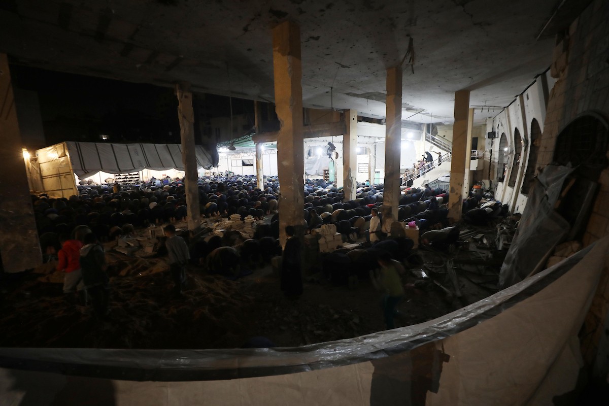 فلسطينيون يؤدون صلاة التراويح في أول ليلة من شهر رمضان على أنقاض مسجد الكنز المدمر في مدينة غزة، في 17 فبراير/شباط 2026. وكان مفتي القدس والأراضي الفلسطينية قد أعلن أن يوم الأربعاء 18 فبراير/شباط 2026 هو أول أيام رمضان. (صورة: عمر أشتوي)