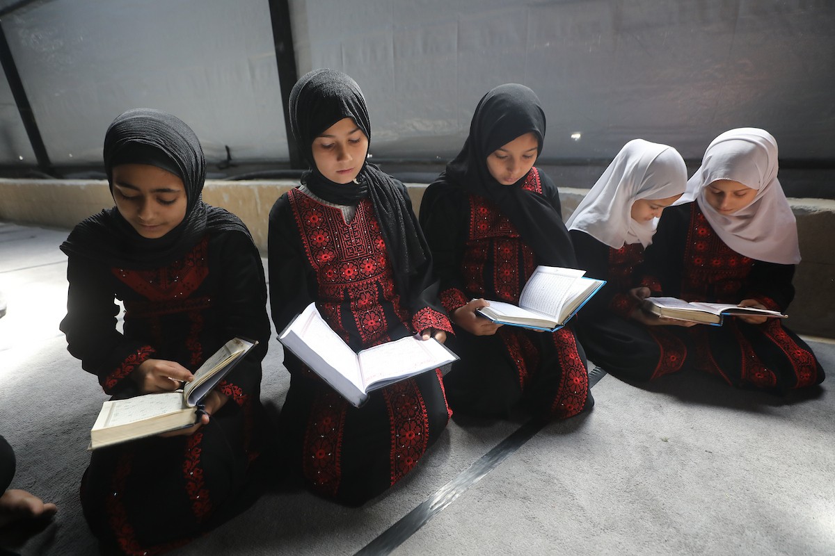 أطفال فلسطينيون يتلون ويحفظون القرآن الكريم داخل الجامع العمري الكبير في مدينة غزة خلال شهر رمضان. وقد تضرر الجامع العمري القديم بشدة جراء الهجمات الإسرائيلية خلال حرب غزة في 26 فبراير/شباط 2026. صورة: عمر أشتوي
