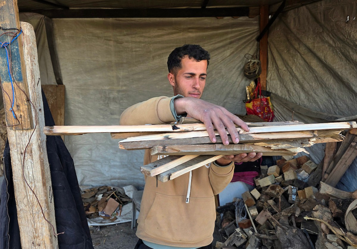 تلجأ العائلات الفلسطينية والباعة إلى استخدام الحطب والخشب لإعداد الطعام بسبب نقص غاز الطهي، خان يونس، جنوب قطاع غزة، 24 فبراير/شباط 2026.تصوير: طارق محمد/ (APA Images).