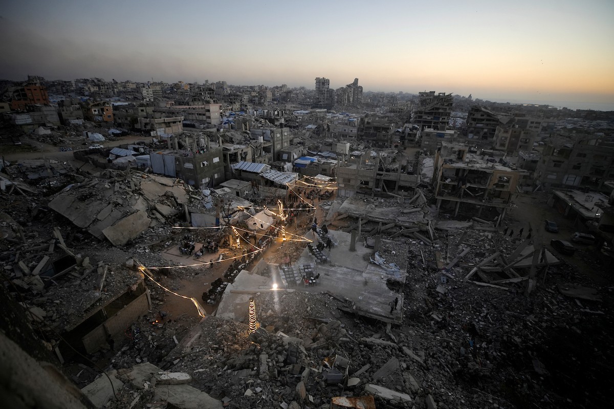 يتجمع الفلسطينيون بين المنازل المدمرة لتناول وجبة الإفطار معًا خلال شهر رمضان المبارك في شمال قطاع غزة، 22 فبراير/شباط 2026. صورة: عمر أشتوي